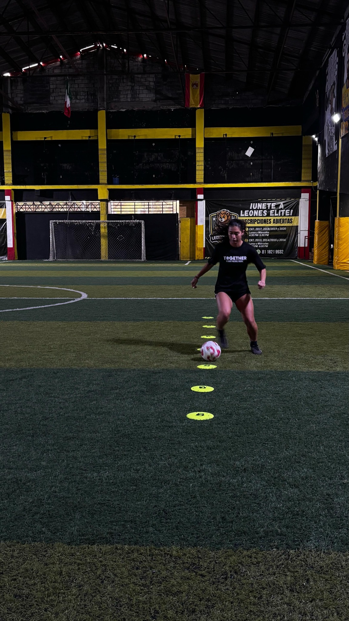 Mujer entrenando con conos en Arena Soccer