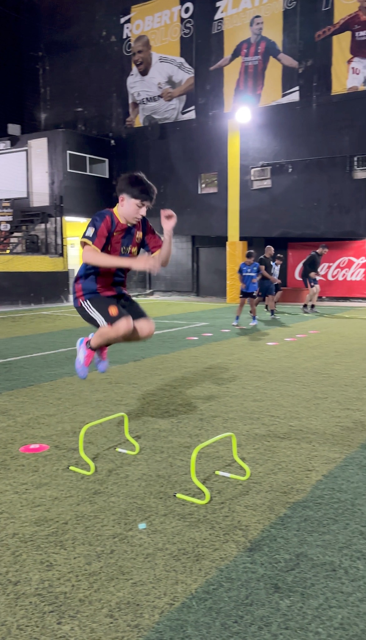 Niño saltando vallas en entrenamiento de agilidad